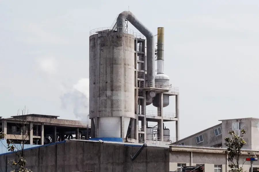 Fábrica em operação vista de fora, com silos e vapor